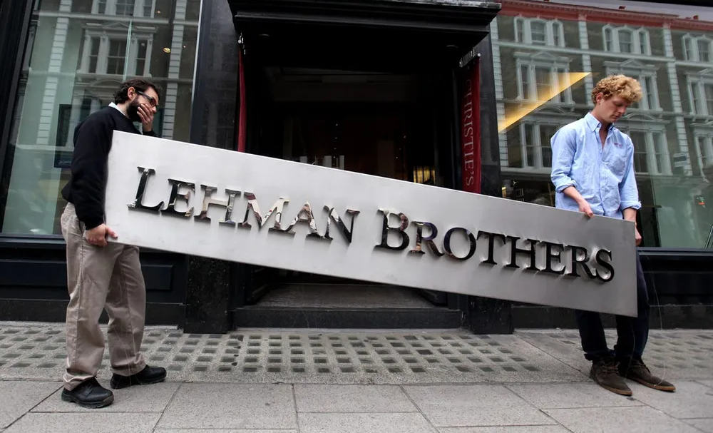 파산한 리먼 브라더스 회사 간판을 내리는 사진입니다.