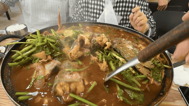연천 아우라지메기매운탕 잡탕에서 두툼한 민물고기 살을 국자로 건져 올리는 모습, 미나리와 얼큰한 국물이 함께 끓는 장면