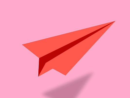 다홍색 종이로 만든 종이 비행기가 있다.