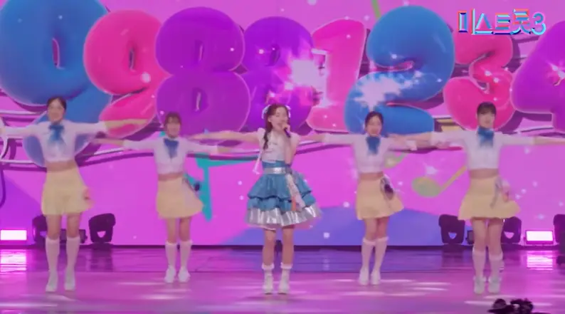 미스트롯3- 보라색 배경 앞 백댄서 4명 사이에서 흰망사한복 파란 미니스커트를 입고 노래하는 나영