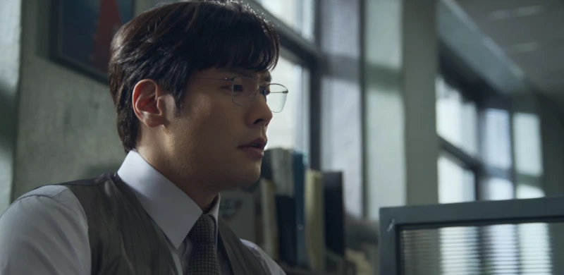 사무실을 배경으로 책상에 앉아 모니터를 바라보고 있는 드라마 마스크걸의 박기훈 팀장 캐릭터