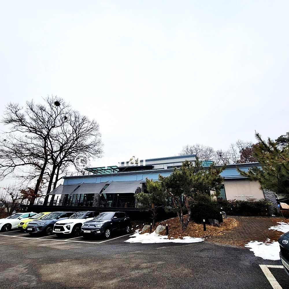 515더오리지널 건물앞에 주차장이 마련되어 있고, 차량들이 주차되어 있다.