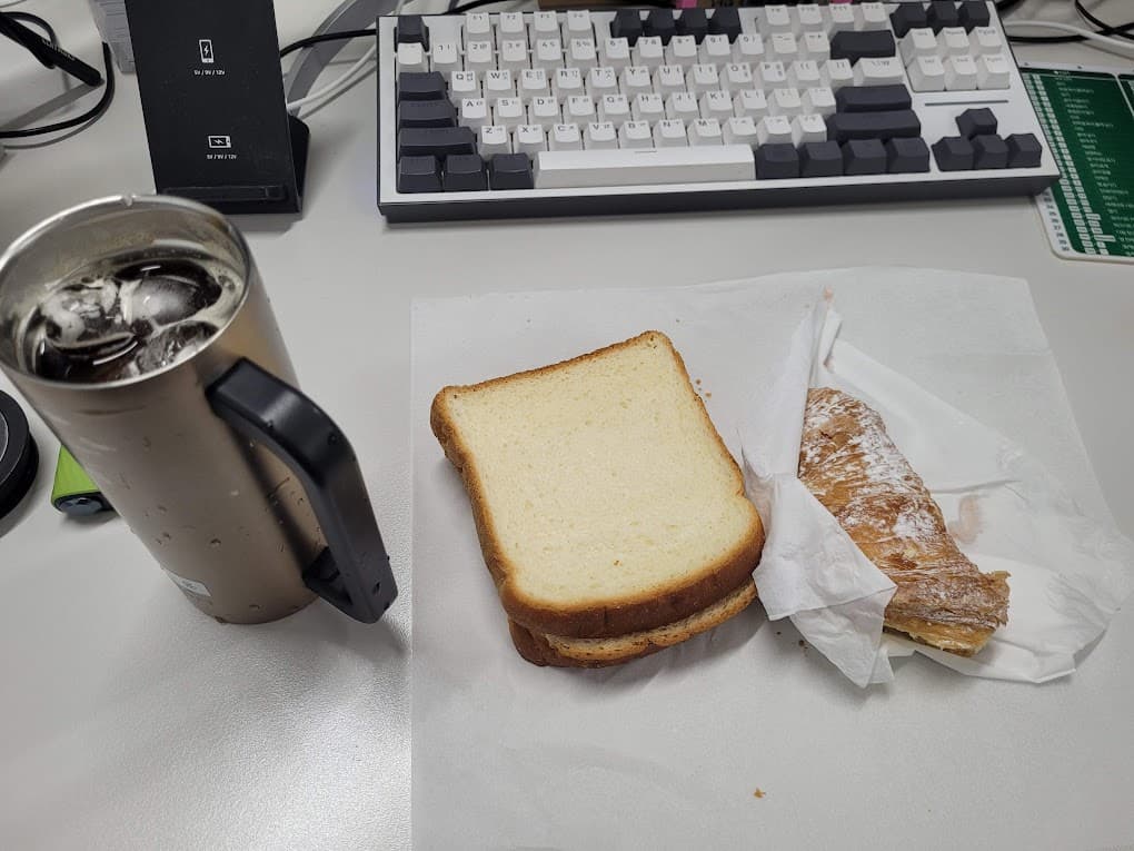 회사 책상위 커피와 빵 그리고 키보드