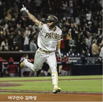 김하성 골든글러브 / 김하성 샌디에이고 유니폼 입고 오른팔을 들고 뛰는 모습