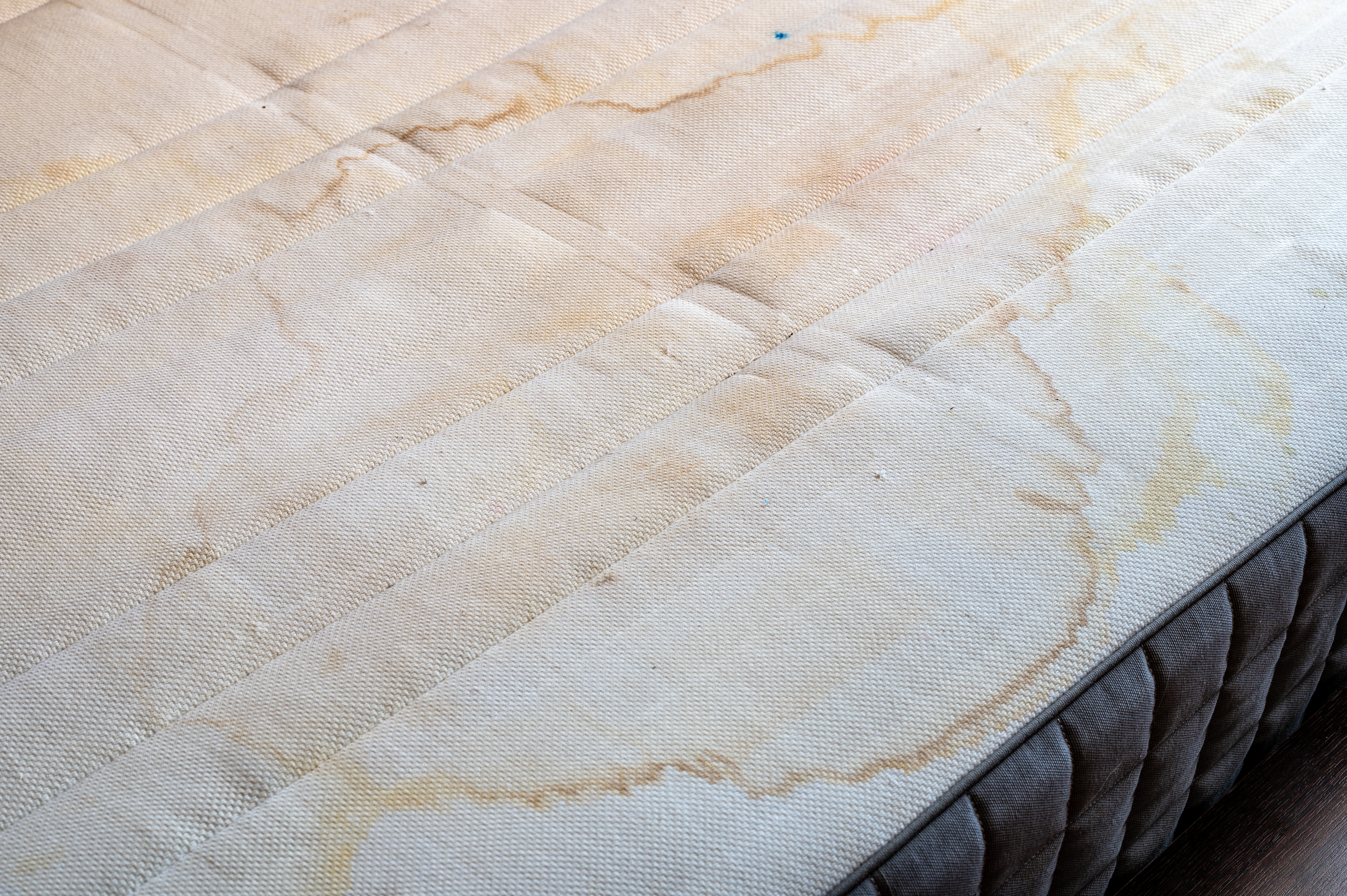 땀과 습기로 인해 누렇게 얼룩진 여름철 매트리스 표면의 곰팡이 및 오염 자국 모습