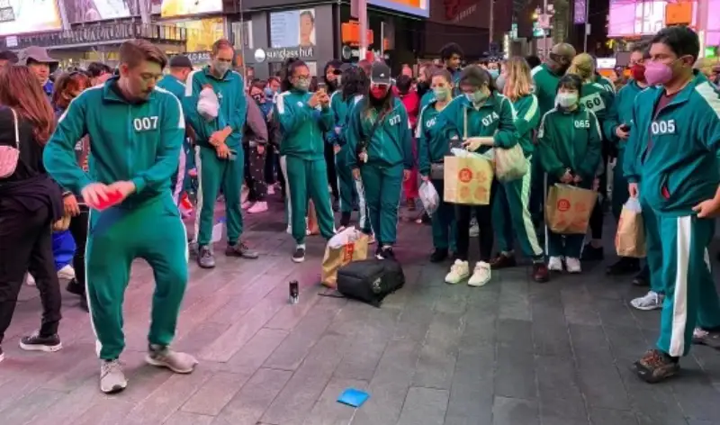 외국인들이 초록색 츄리닝을 입고 길거리에서 딱지치기 하는 모습