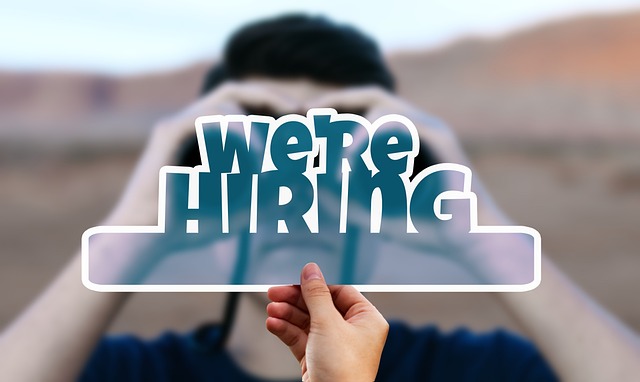 망원경을 보고 있는 사람위에 we are hiring.이라고 써있는 사진