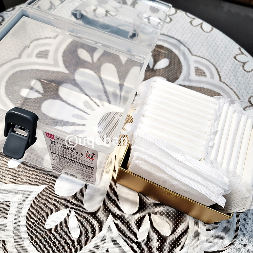 테이블위에 다이소 스톡박스와 위생용품이 담겨진 작은 상자가 올려져있다.