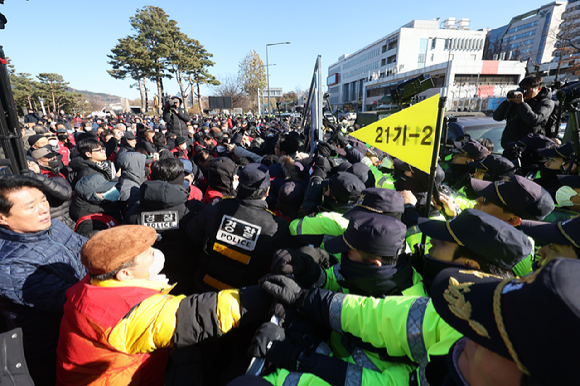 30일 오후 서울 용산구 대통령실 앞에서 열린 개식용 금지법안 추진 반대 집회에서 대한육견협회 관계자들이 식용견을 싣고 온 자신들의 트럭을 견인하려는 경찰들과 몸싸움을 벌이고 있다. [사진=뉴시스]