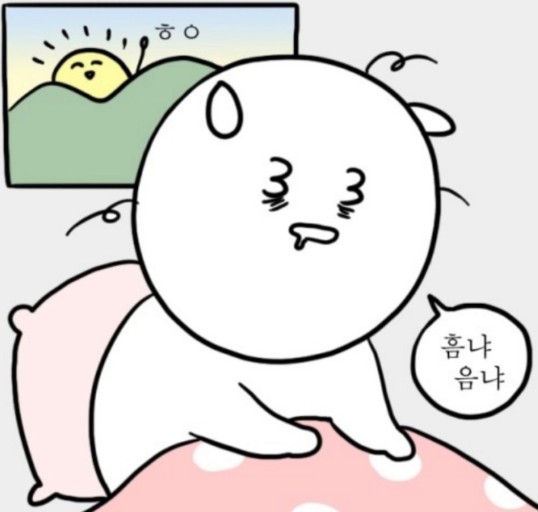 웹툰 대학일기의 &#39;자까&#39; 캐릭터가 아침에 잠에서 덜 깬 채 침대에서 졸고 있는 모습이다.