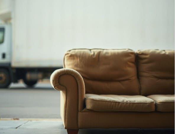 폐기물수거 트럭과 수거 예정인 소파가 있습니다.