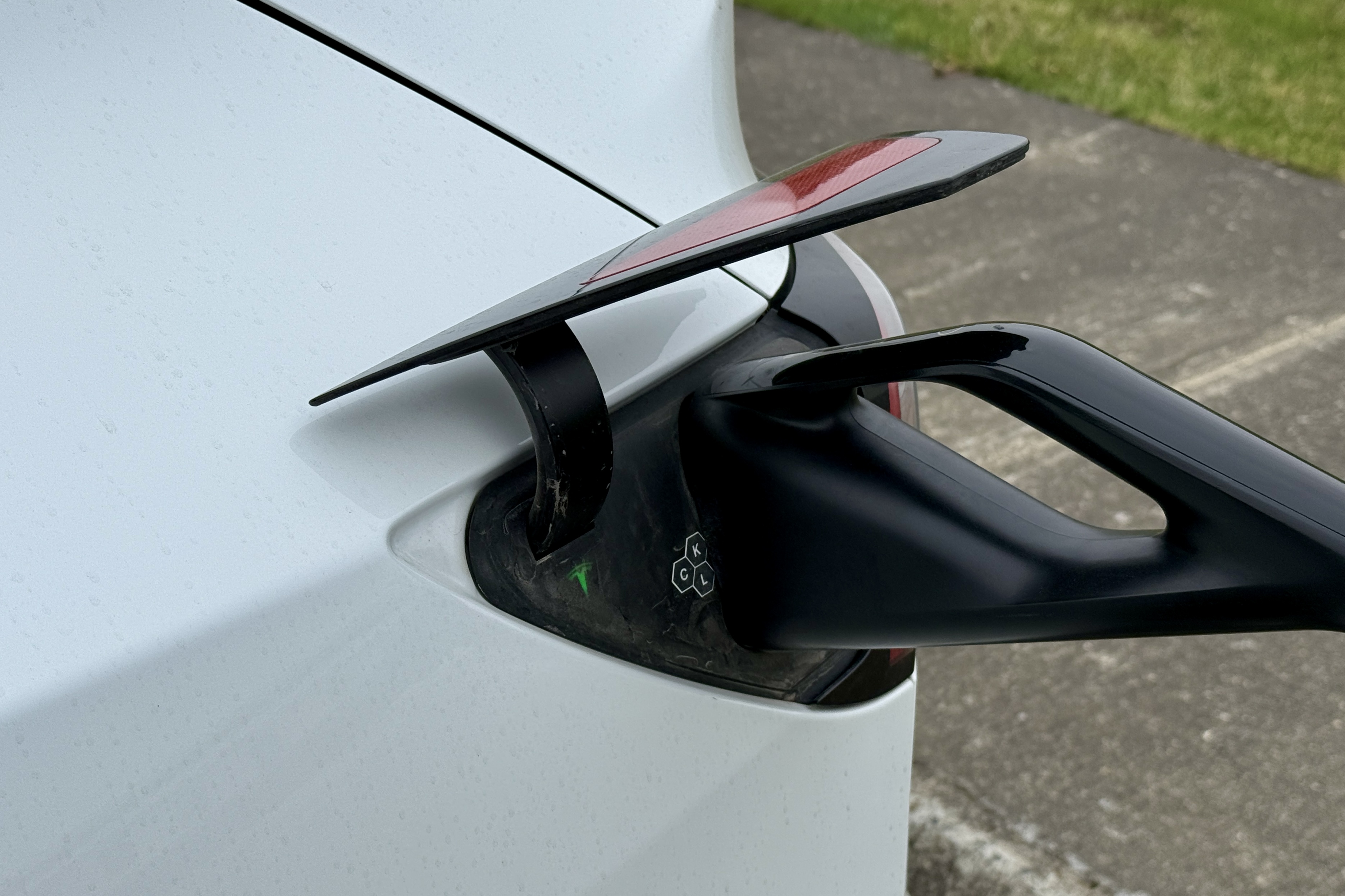 테슬라 차량의 충전 포트에 연결된 충전기 케이블, 충전 중인 상태