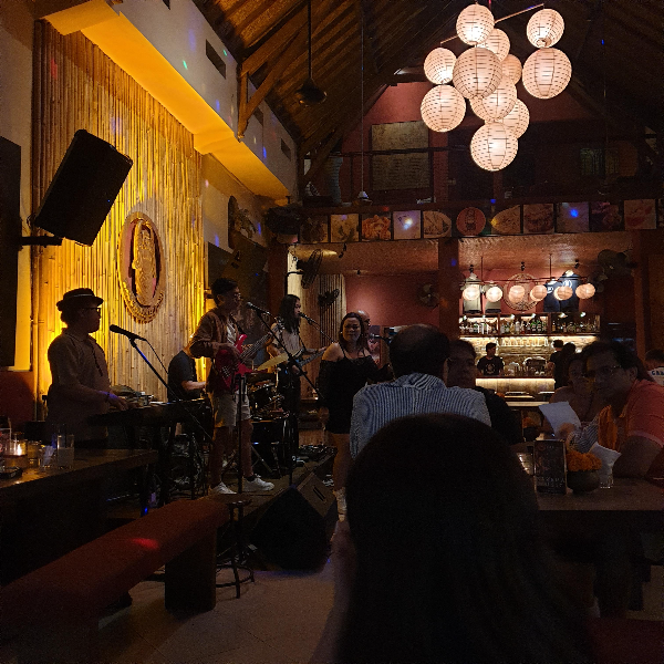 밴드가 공연하는 모습 어두운 조명에 무대에만 조명이 있다.