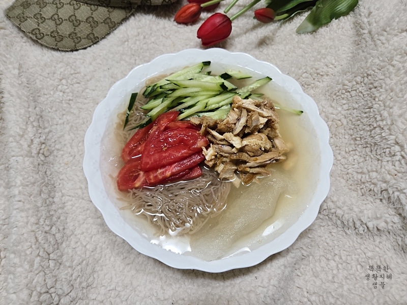 오이와 토마토 고명이 올라간 냉면 사진