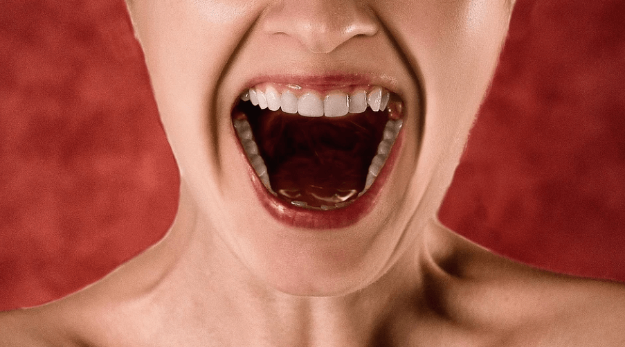 입을 크게 벌리고 고함을 지르고 있는 여성