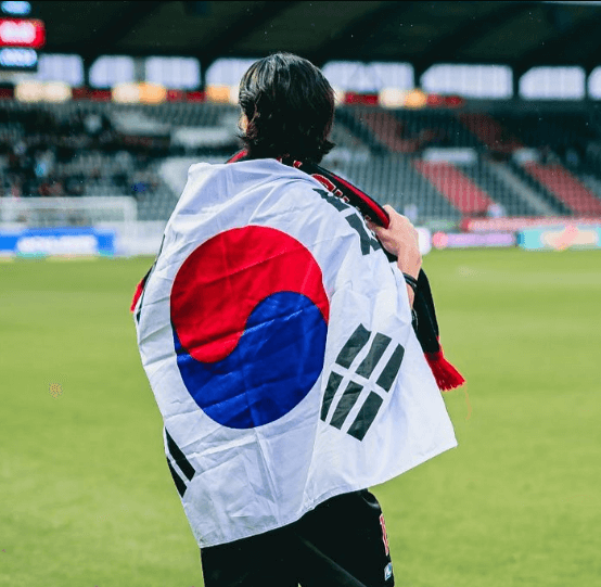 조규성 선수가 경기장에서 태극기를 등에 걸치고 있는 뒷모습