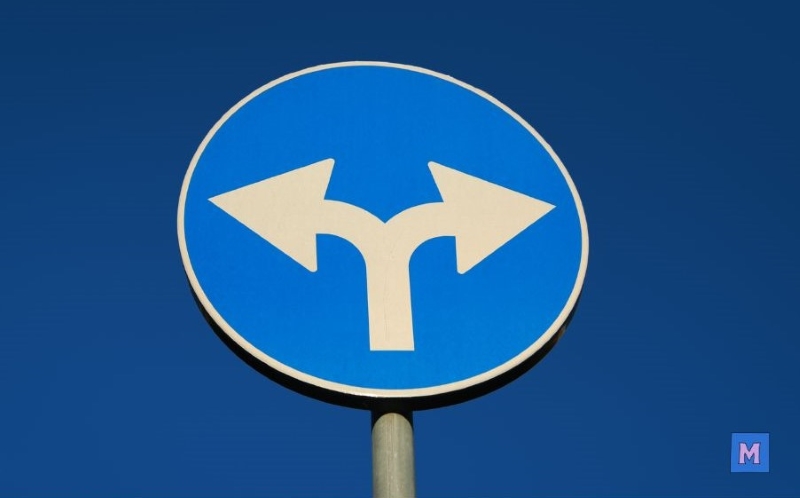 파란색 원형 교통표지판에 두 방향으로 갈라지는 화살표가 그려져 있어 선택과 유연성을 상징 via canva