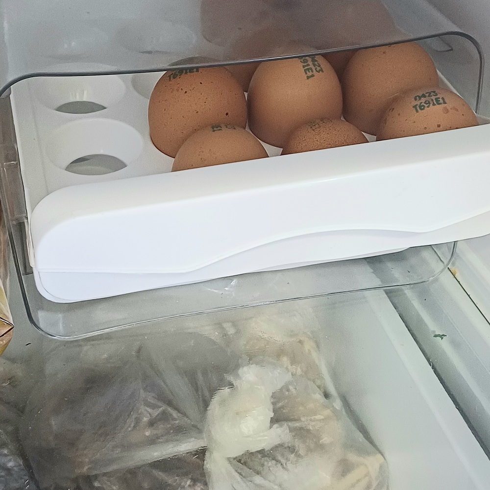 냉장고 안쪽 선반에 계란을 둥근 부분은 위로, 뾰족한 부분은 아래로 보관한 모습