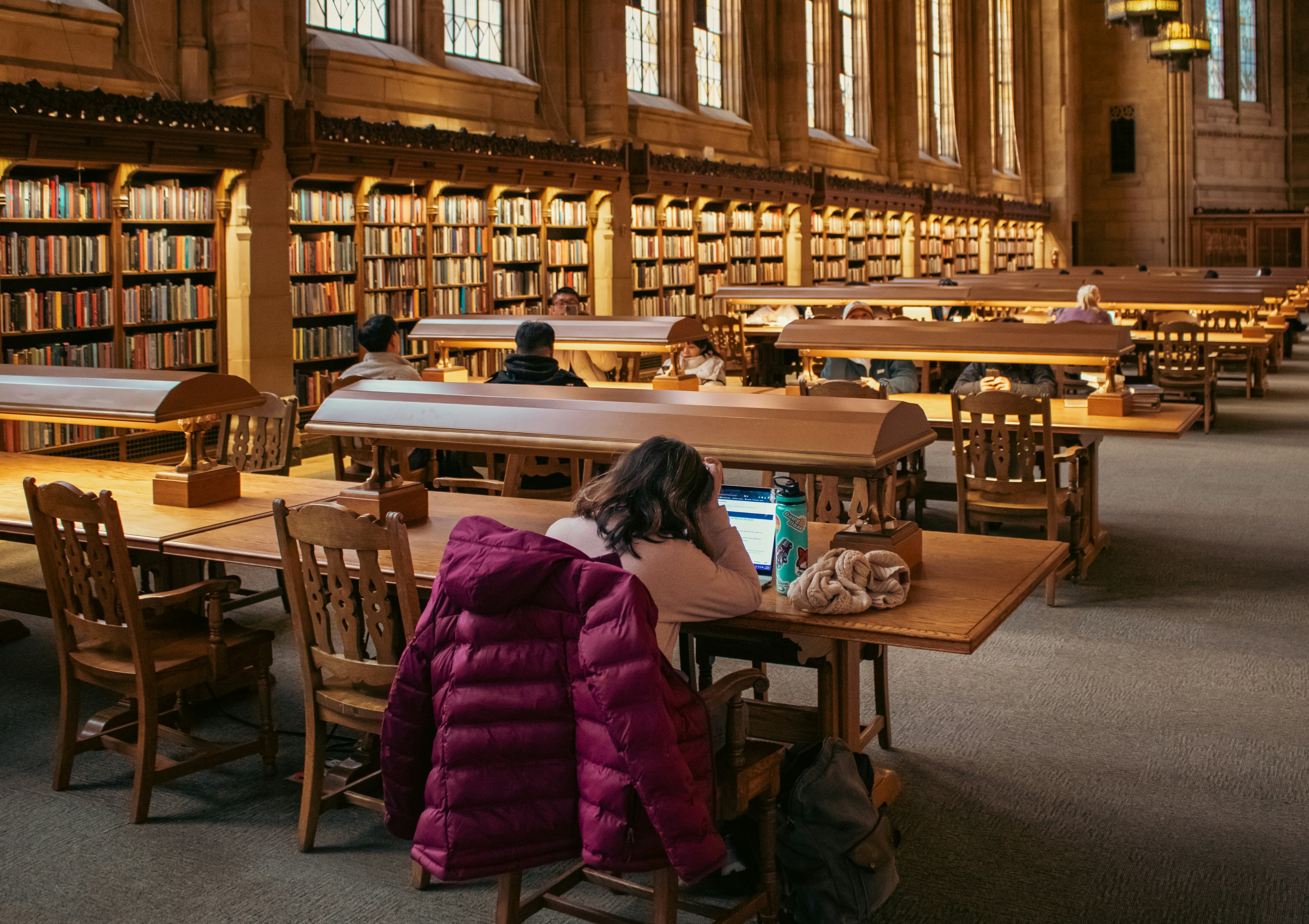 도서관에서 노트북을 보며 공부하다가 지쳐 머리를 괴고 있는 학생 모습, 스트레스와 피로를 표현