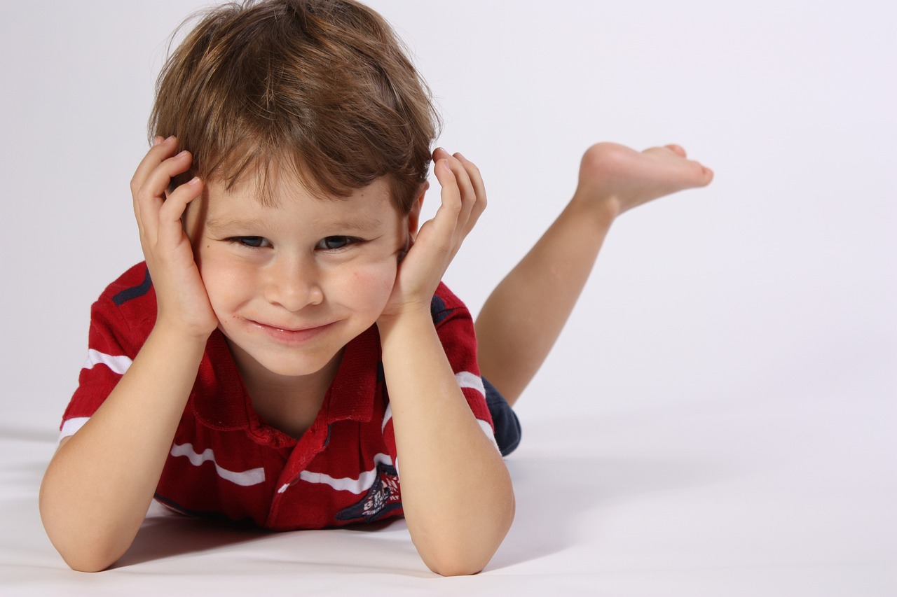 아이가 턱을 고이고 누워있다.