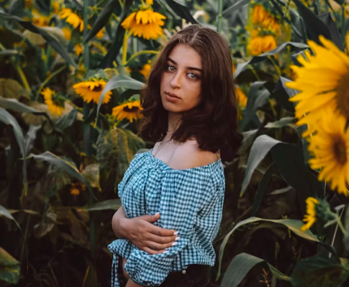 해바라기 속에서 카메라를 쳐다보고 있는 여자의 모습