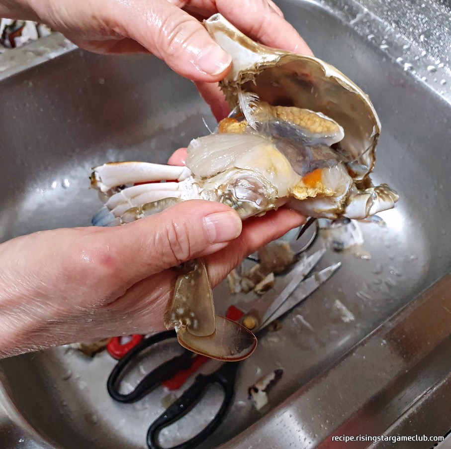 맛있는 양념게장에 들어갈 꽃게를 몸통과 딱지로 분리하는 사진