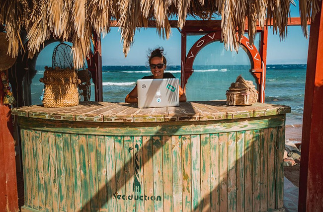 해변가에서 노트북 하는 여자 사진