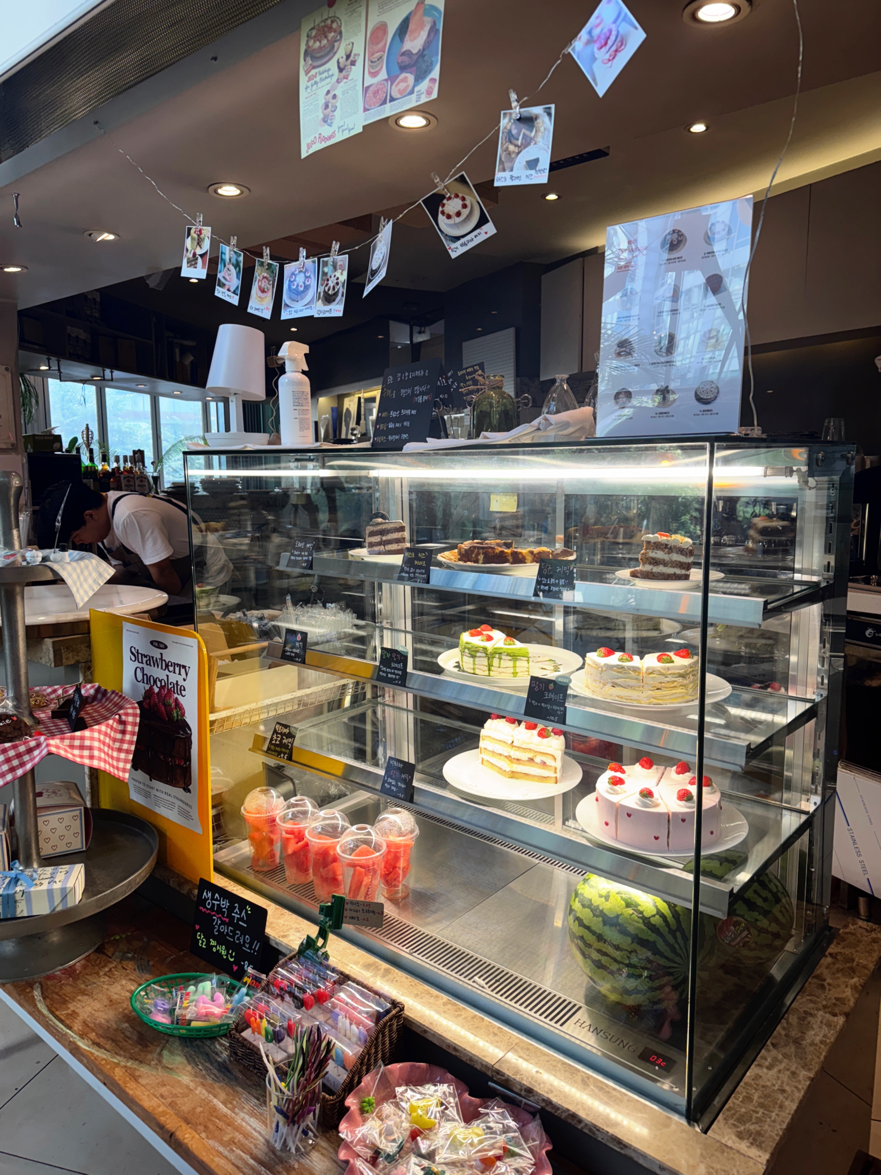 정자동 엑성프로방스 카페 디저트 진열대 &ndash; 말차 크레이프 케이크&amp;#44; 딸기 케이크&amp;#44; 수박과 다양한 디저트가 진열된 모습