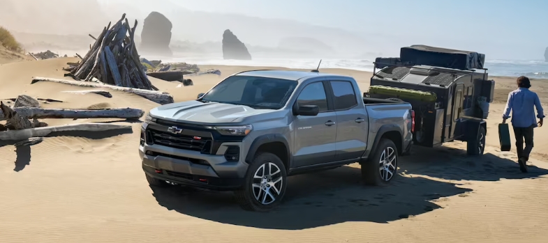 2023 쉐보레 콜로라도 풀체인지 모델이 해변의 모래사장에서 트레일러를 끌고있다.