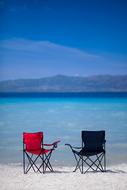 해변가에-빨간색과-검은색의-의자가-있습니다.