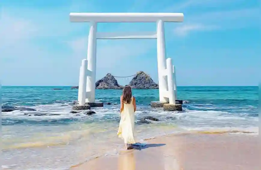 후쿠오카 이토시마 1일 버스 투어의 대표 명소, 바다 위 하얀 토리이(신사 입구)와 새끼줄로 이어진 부부바위(메오토이와)의 아름다운 풍경. 에메랄드빛 바다와 파란 하늘이 어우러져 인생샷을 남기기 좋습니다.