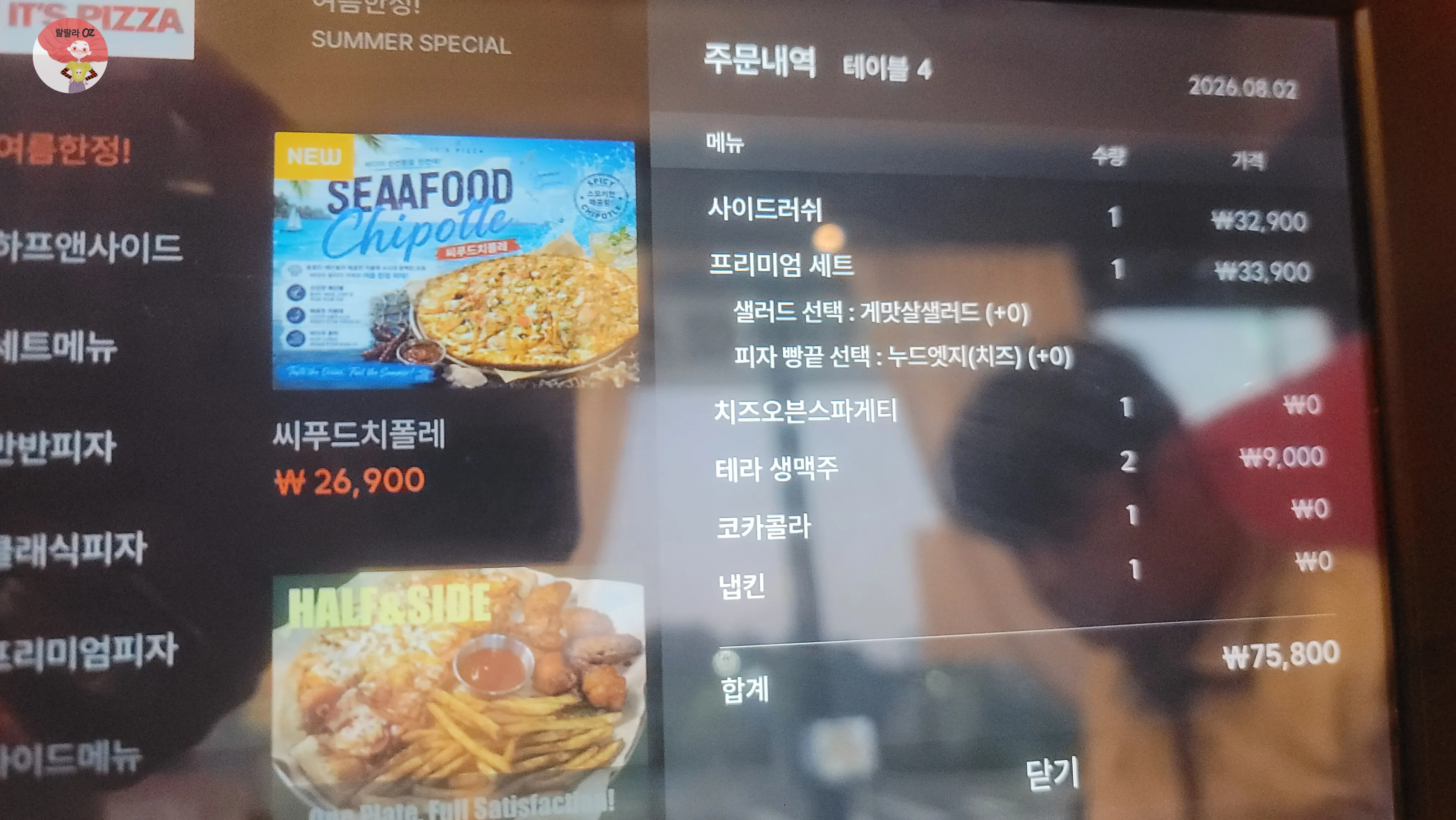 키오스크 주문 화면에 표시된 메뉴와 가격, 반사된 주변 모습이 함께 보이는 장면