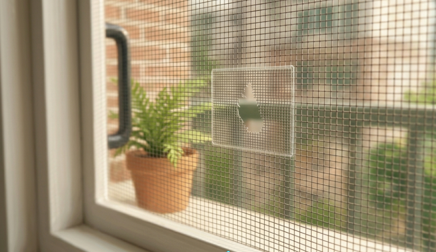 찢어진 아파트 방충망 구멍에 보수용 테이프를 붙이는 모습