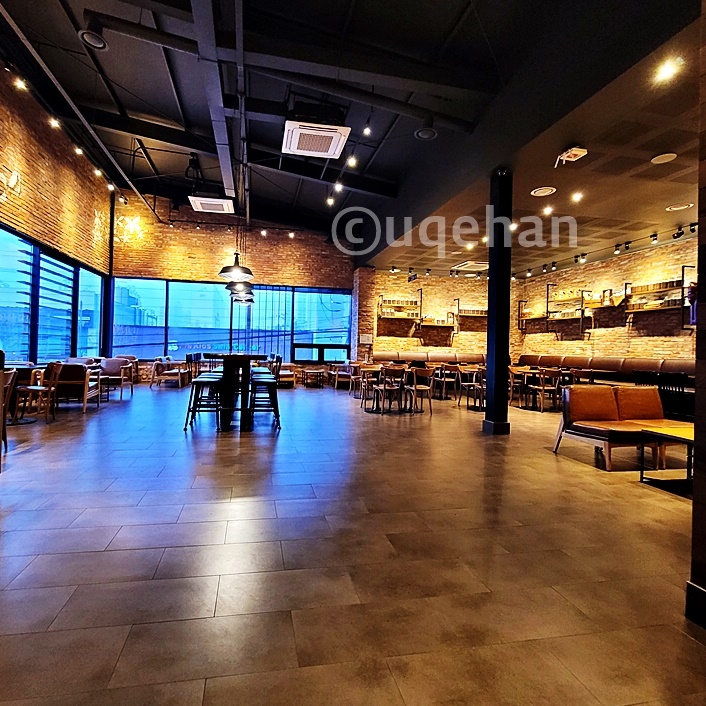 스타벅스 동두천 DT 2층의 전경이다. 넓은 공간에 테이블과 소파들이 배치되어있다.