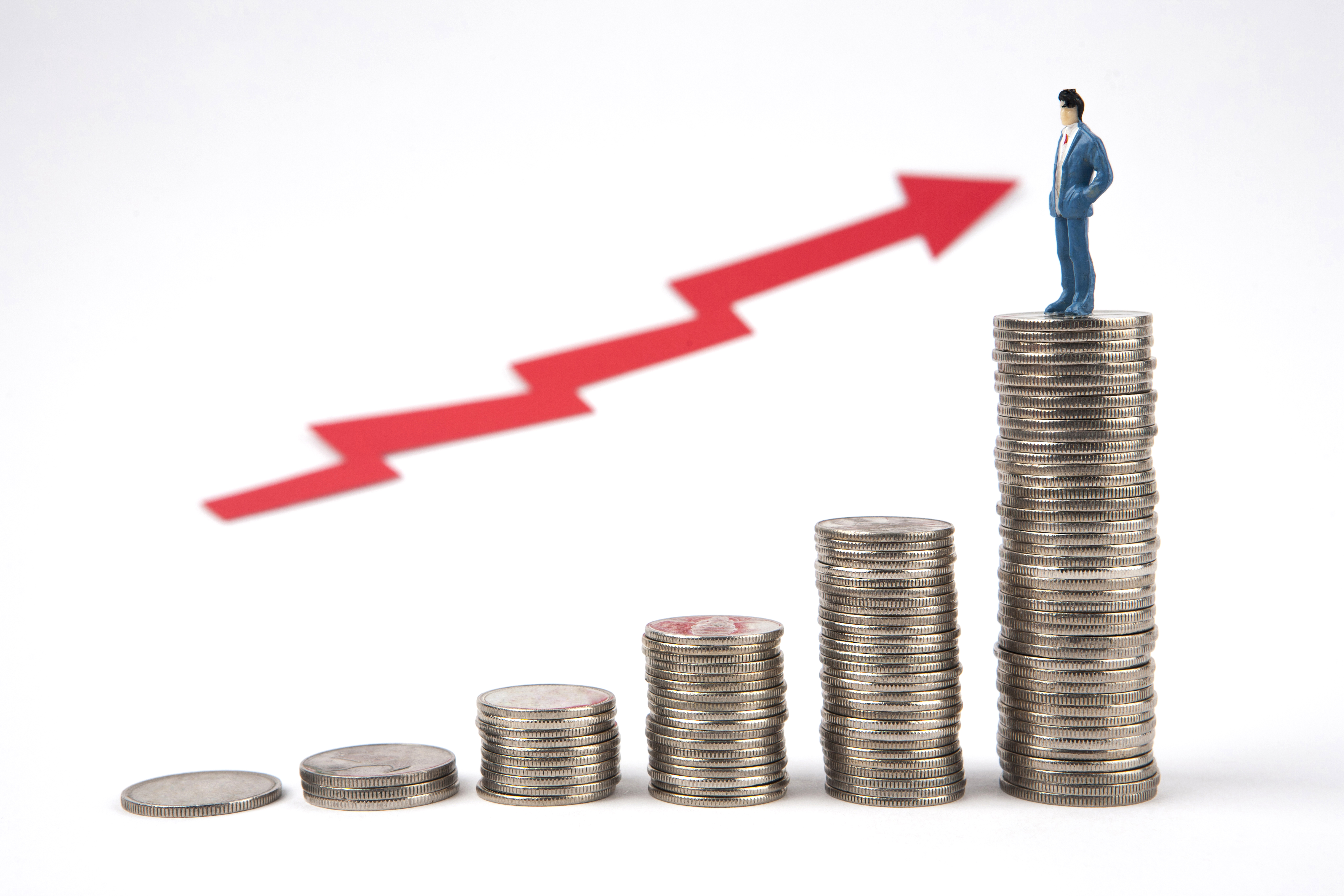 동전 위에 서 있는 작은 사람 모형과 상승 화살표를 통한 자산 성장 개념