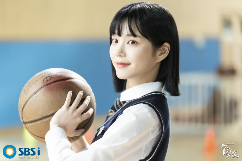 농구장 코트에 단발머리에 교복을 입고 농구공을 두손에 들고 서 있는 드라마 7인의 탈출의 한모네 캐릭터