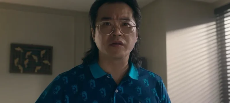 파랑 티셔츠에 안경을 쓰고 긴 파마 머리를 하고 드라마 무빙의 정상진 캐릭터