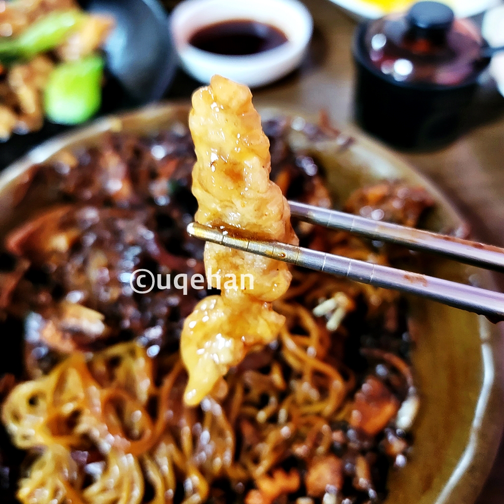 아랫쪽에는 짜장면이 있고, 탕수육을 젓가락을 들고있는 사진이다.