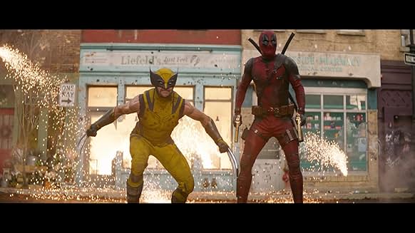 도심 속에서 울버린과 데드풀이 나란히 액션 자세를 취하며 폭발을 배경으로 한 장면