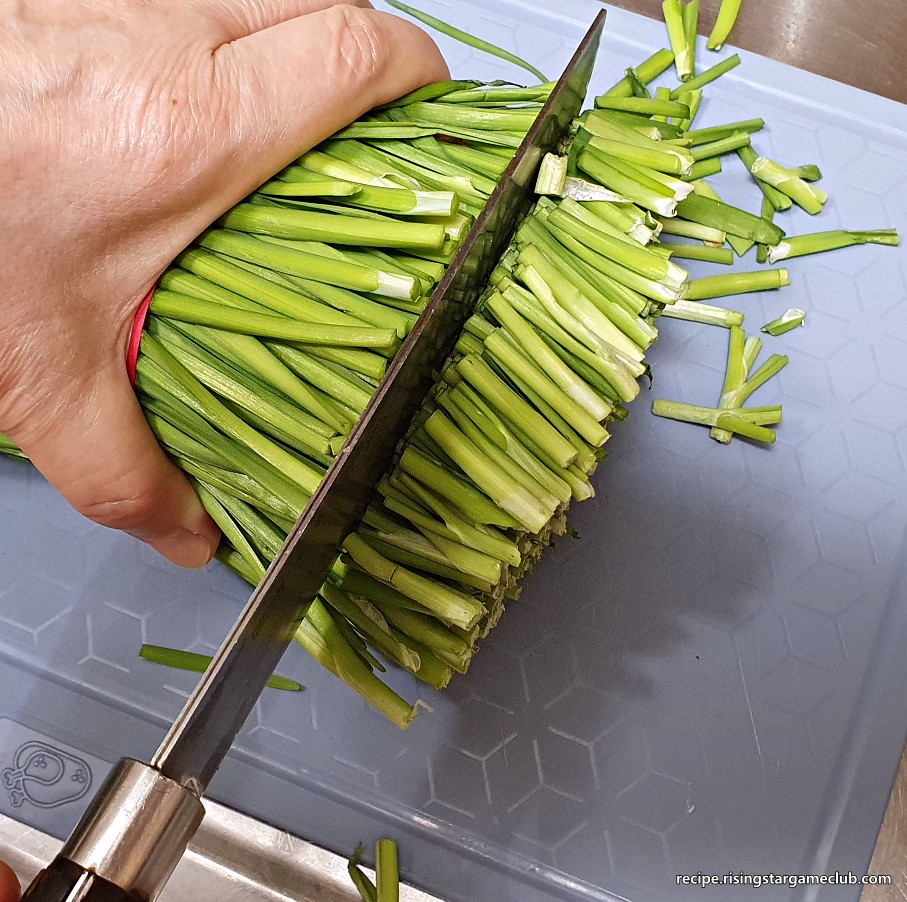 부추 겉절이를 만들기 위해 부추 밑둥을 2cm정도 자르는 사진