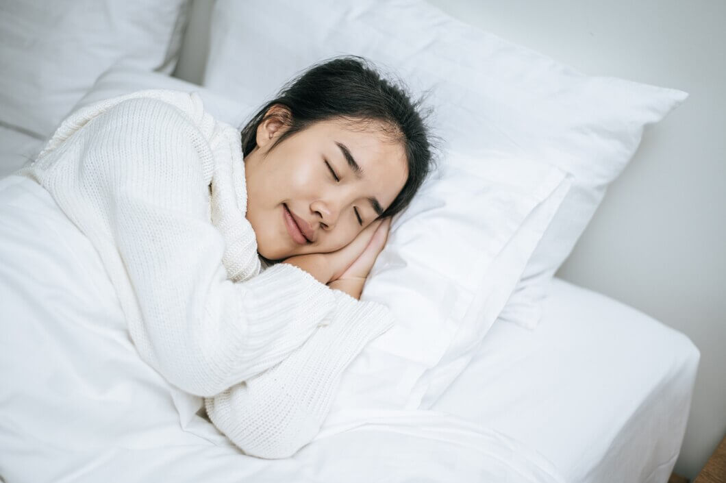 침대에서 잠을 자는 여자