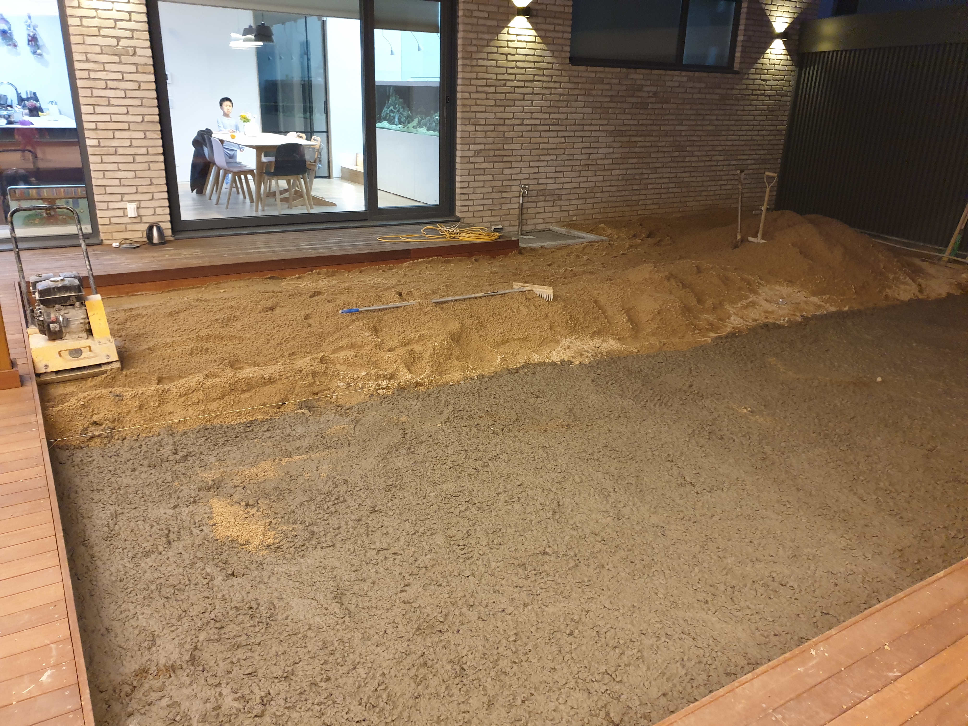 마당을 반으로 나누어 한 쪽에 잔디를 심고 있는 모습