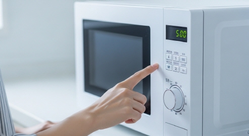 전자레인지 타이머를 5분으로 맞추는 모습