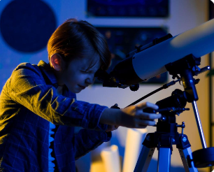 망원경으로 하늘을 관찰하며 우주과학에 흥미를 갖게 된 아이