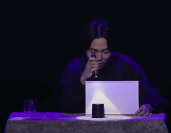 DK 마술사가 검은색 컵 위로 플래시를 비추고 있다.