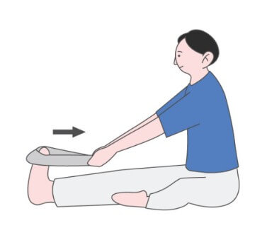 수건으로 발바닥을 당기면서 운동하고 있는 남성