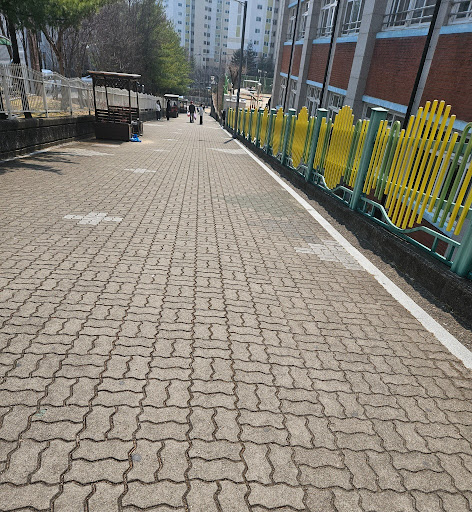 학교 정문 앞에서 하교하는 아이를 기다리는 엄마의 시선과 따뜻한 풍경