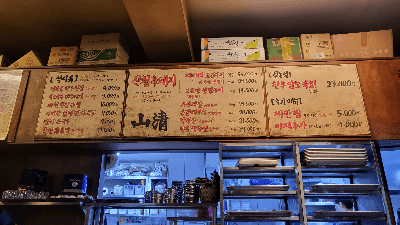 자리에 앉아 메뉴판쪽을 바라보는 사진