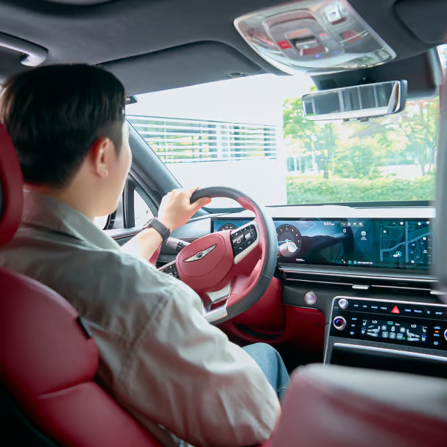 운전석에 앉아 시트와 미러를 조절하는 운전자