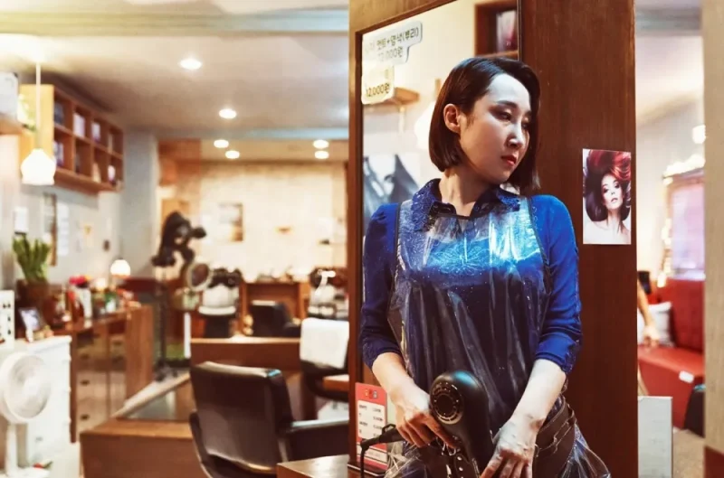 미용실을 배경으로 헤어드라이기를 들고 있는 드라마 무빙의 홍성화 캐릭터